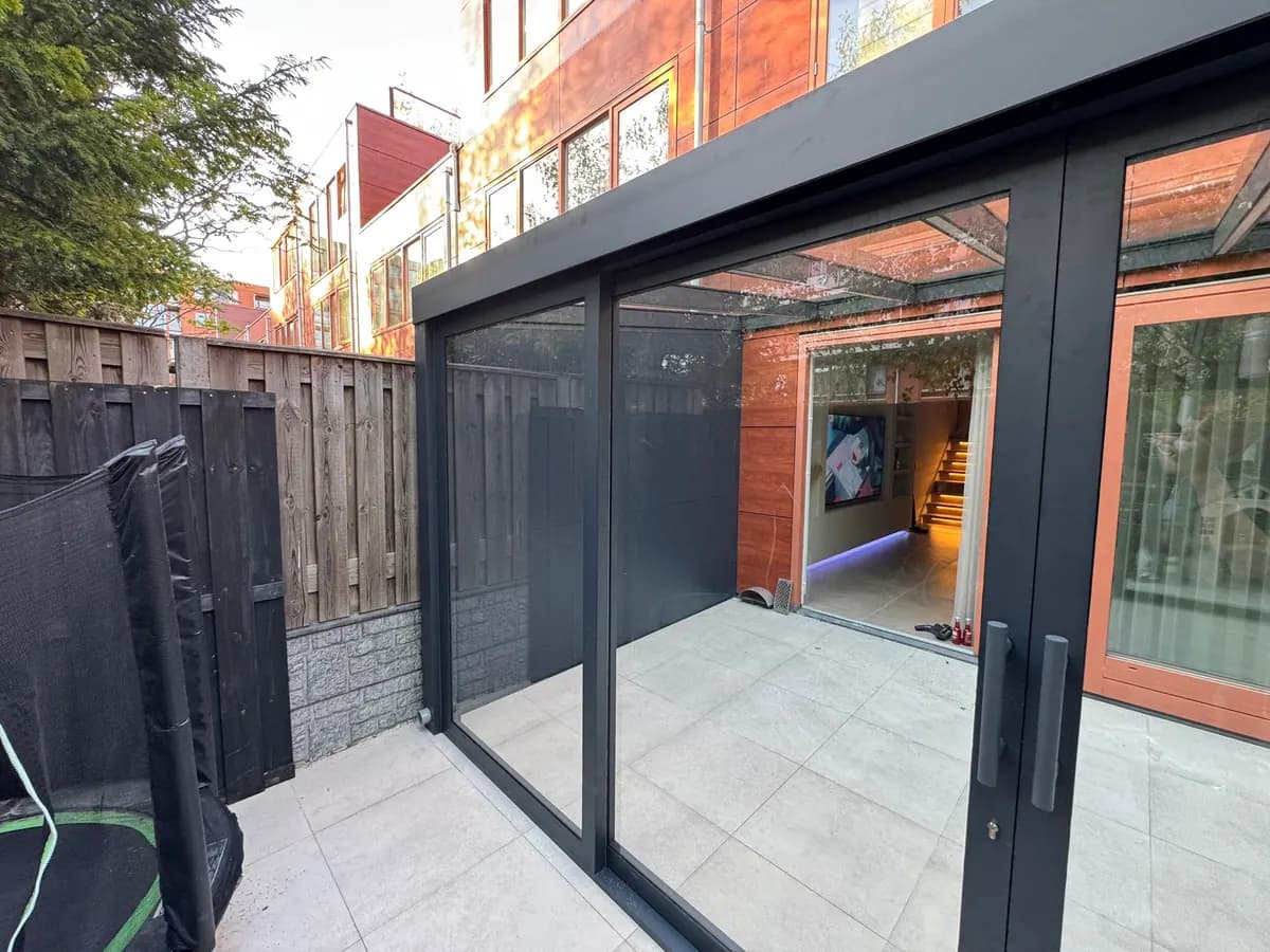 Glazen aanbouw met schuifwand in avondlicht